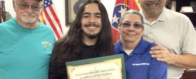 Four individuals pose for a photo; one holds a "Tennessee Sheriffs' Association Certificate of Scholarship" for Lazuras Easterling for $500.00 in 2026. The Tennessee and US flags are visible in the background.