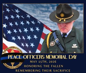 A Williamson County Sheriff’s Office deputy stands in ceremonial uniform with head bowed in front of a large American flag under a cloudy sky. A black mourning band is displayed across the Sheriff’s Office badge in the lower corner. The graphic reads: “Peace Officers Memorial Day, May 15th, 2026, Honoring the Fallen, Remembering Their Sacrifice.” The image honors law enforcement officers who lost their lives in the line of duty.