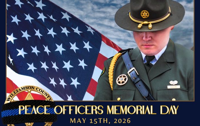 A Williamson County Sheriff’s Office deputy stands in ceremonial uniform with head bowed in front of a large American flag under a cloudy sky. A black mourning band is displayed across the Sheriff’s Office badge in the lower corner. The graphic reads: “Peace Officers Memorial Day, May 15th, 2026, Honoring the Fallen, Remembering Their Sacrifice.” The image honors law enforcement officers who lost their lives in the line of duty.