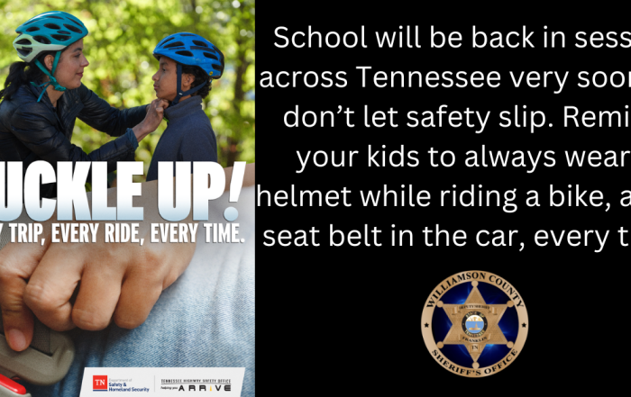 Two kids wearing helmets next to tree with caption "Buckle Up"