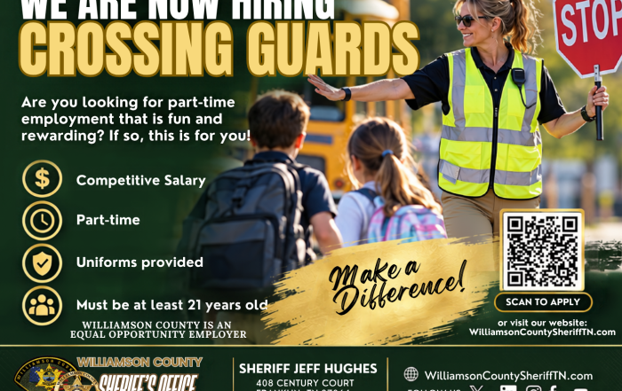 Williamson County Sheriff’s Office recruitment graphic announcing, “We Are Now Hiring Crossing Guards.” A school crossing guard wearing a reflective safety vest holds a stop sign while helping two children cross near a school bus. The graphic highlights competitive salary, part-time work, uniforms provided, and a minimum age of 21. It includes the message “Make a Difference,” a QR code to apply, WilliamsonCountySheriffTN.com, WCSO branding, Sheriff Jeff Hughes’ name and office contact information.