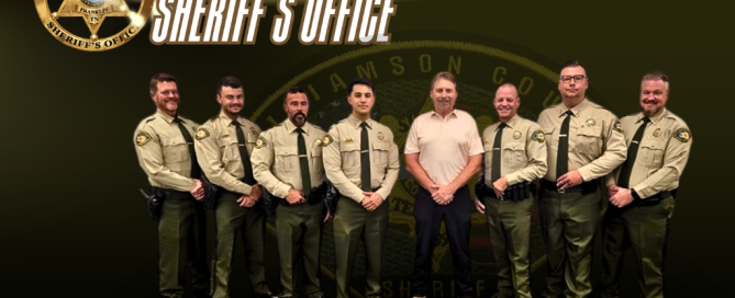 Seven uniformed deputies stand alongside a man in a tan polo shirt. The graphic features a gold badge, the heading “Williamson County Sheriff’s Office” and a faint Office emblem on a dark olive and black background. The footer reads “Sheriff Jeff Hughes” and includes 408 Century Court, Franklin, TN 37064; WilliamsonCountySheriffTN.com; and social media icons.
